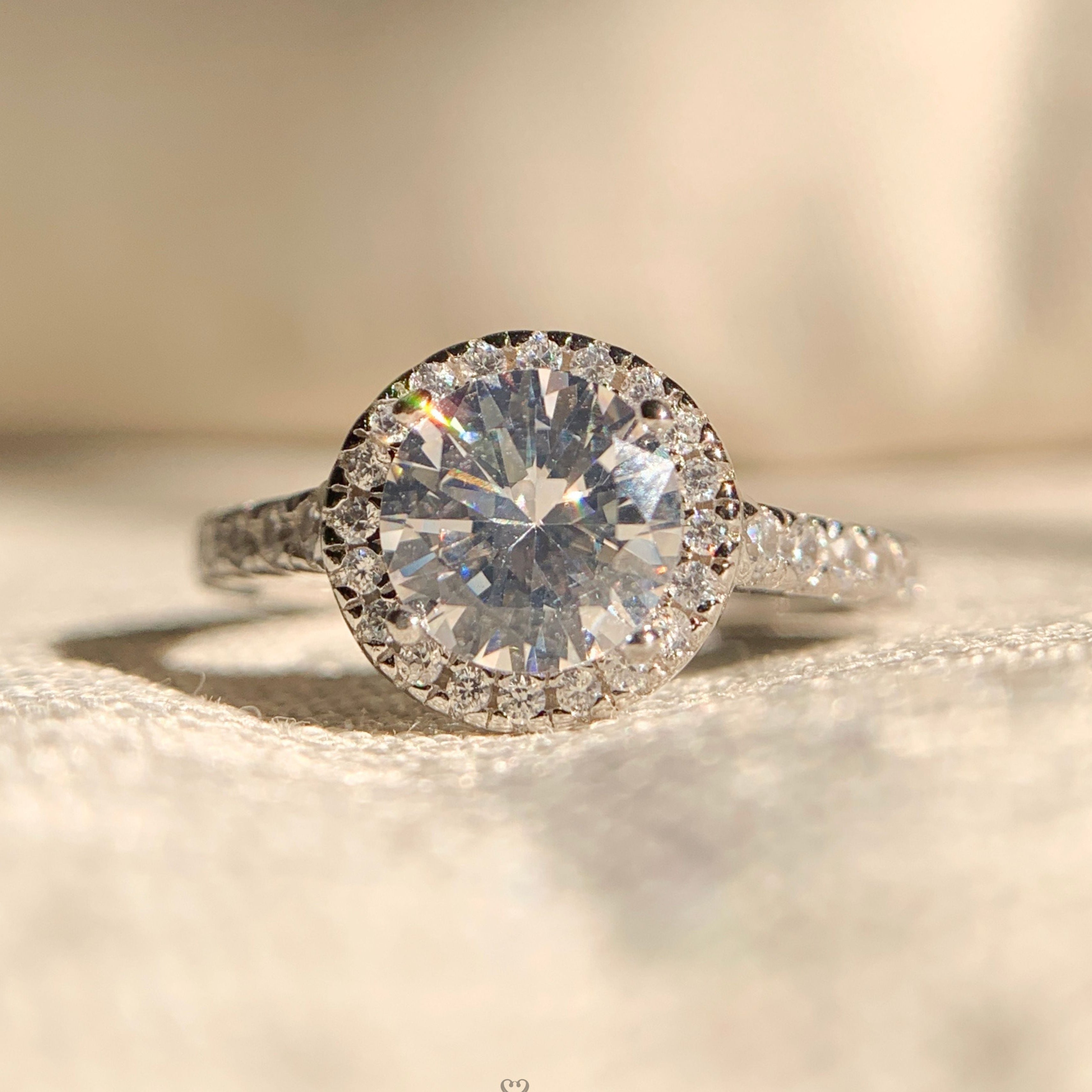 “1.0 carat round halo diamond engagement ring in classic white gold setting”